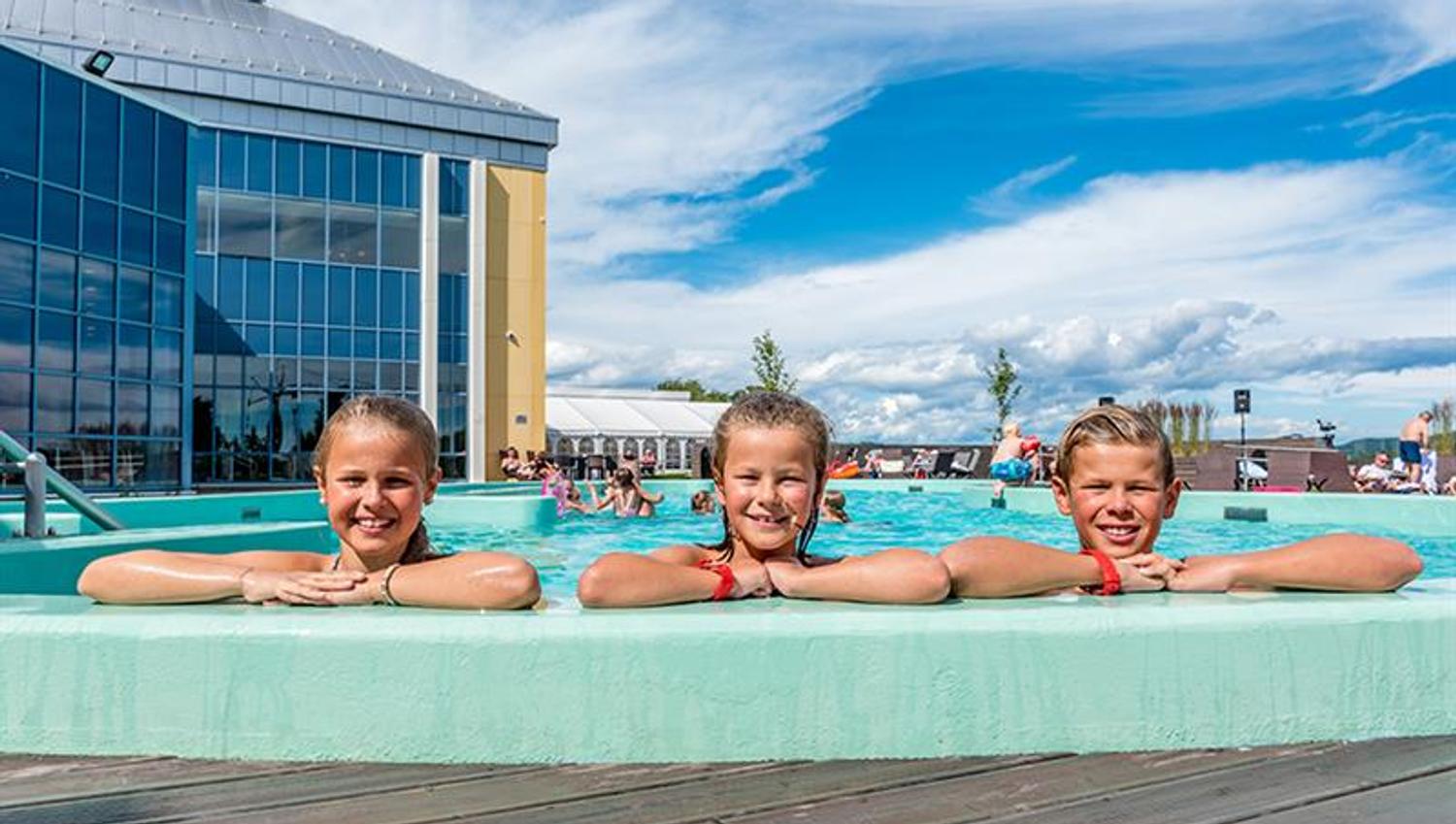 3 children look over the pool edge at the outdoor pool to Badeparken at Quality Hotel Skjærgården in Langesund