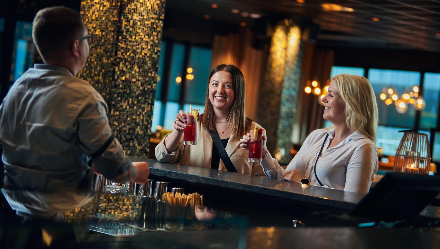 Two ladies enjoy a drink at a bar counter