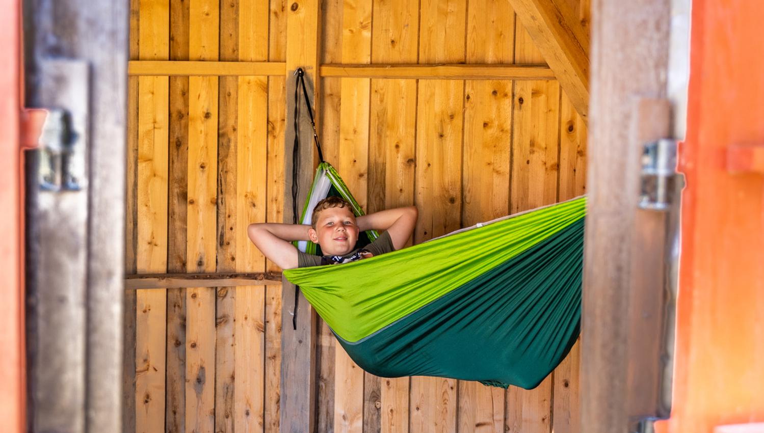 boy in a hammock in a hut