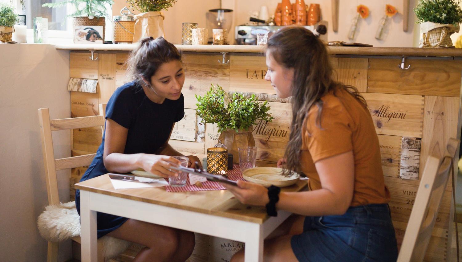 Two girls look at the menu together