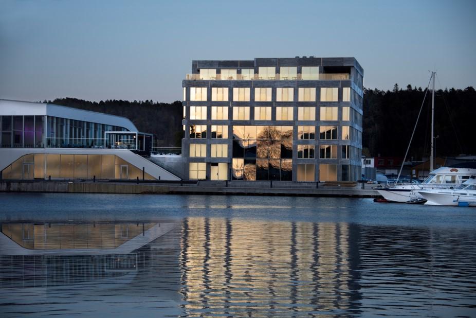 Fasade Mandal Hotel, som speiler seg i Mandalselva ved siden av Buen Kulturhus