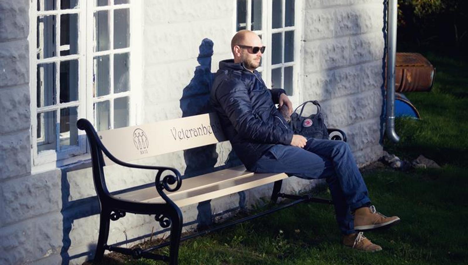 en mann som sitter på en benk