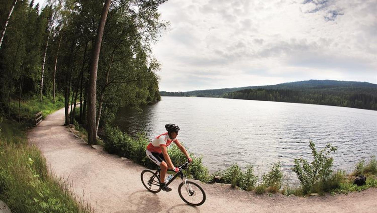 syklist som sykler på tursti rundt et vann