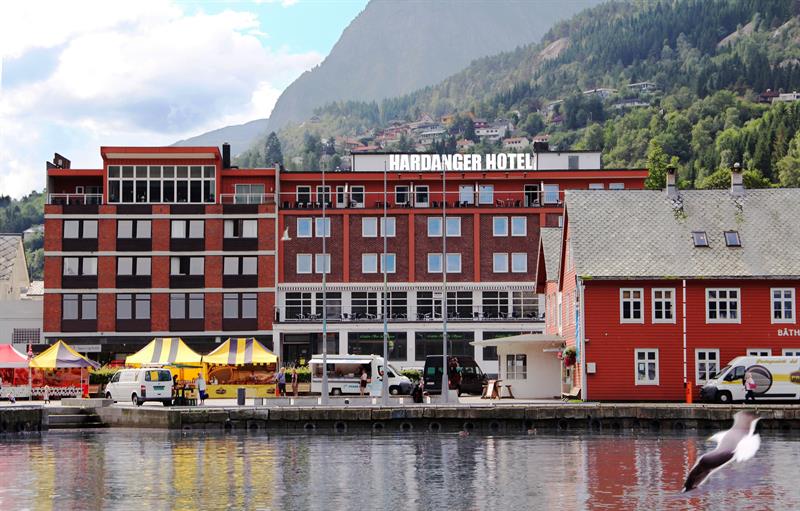 Hardanger Hotel by the fjord with local market stalls and majestic surrounding mountains.