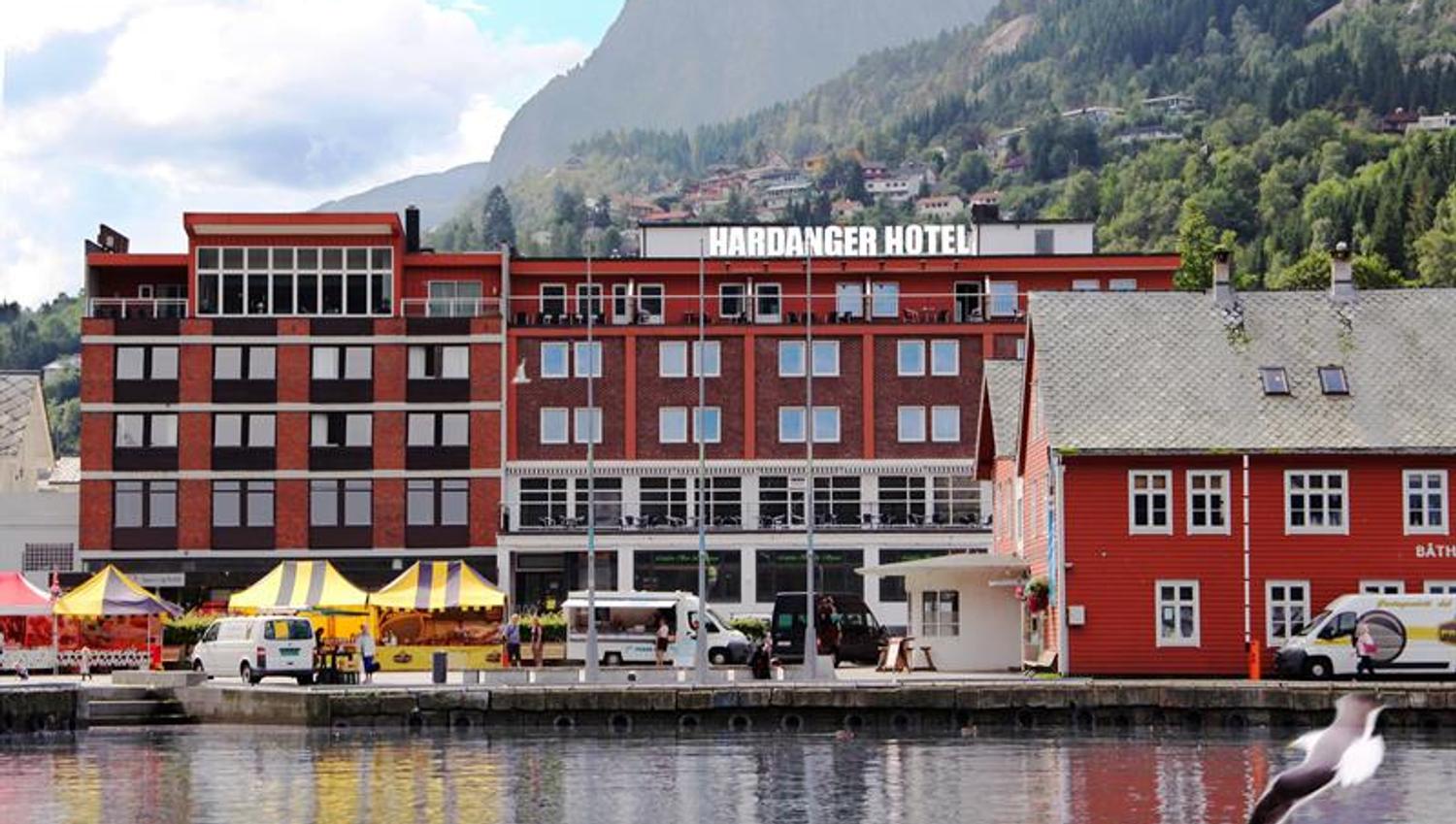Hardanger Hotel by the fjord with local market stalls and majestic surrounding mountains.