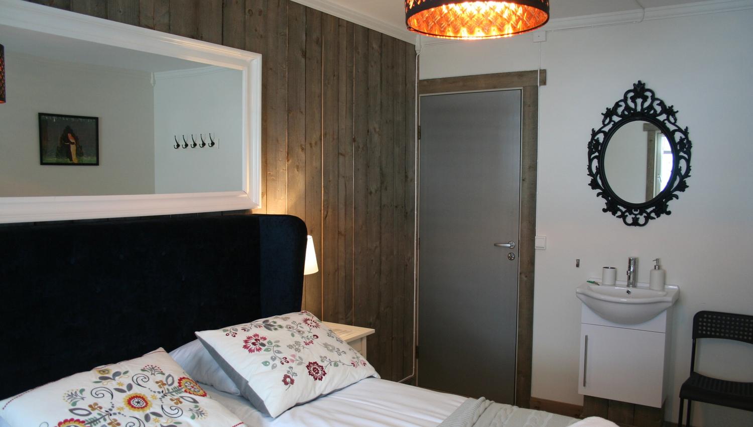 Bright and cozy room at Kvamseter Lodge with classic interior design and wall mirror.