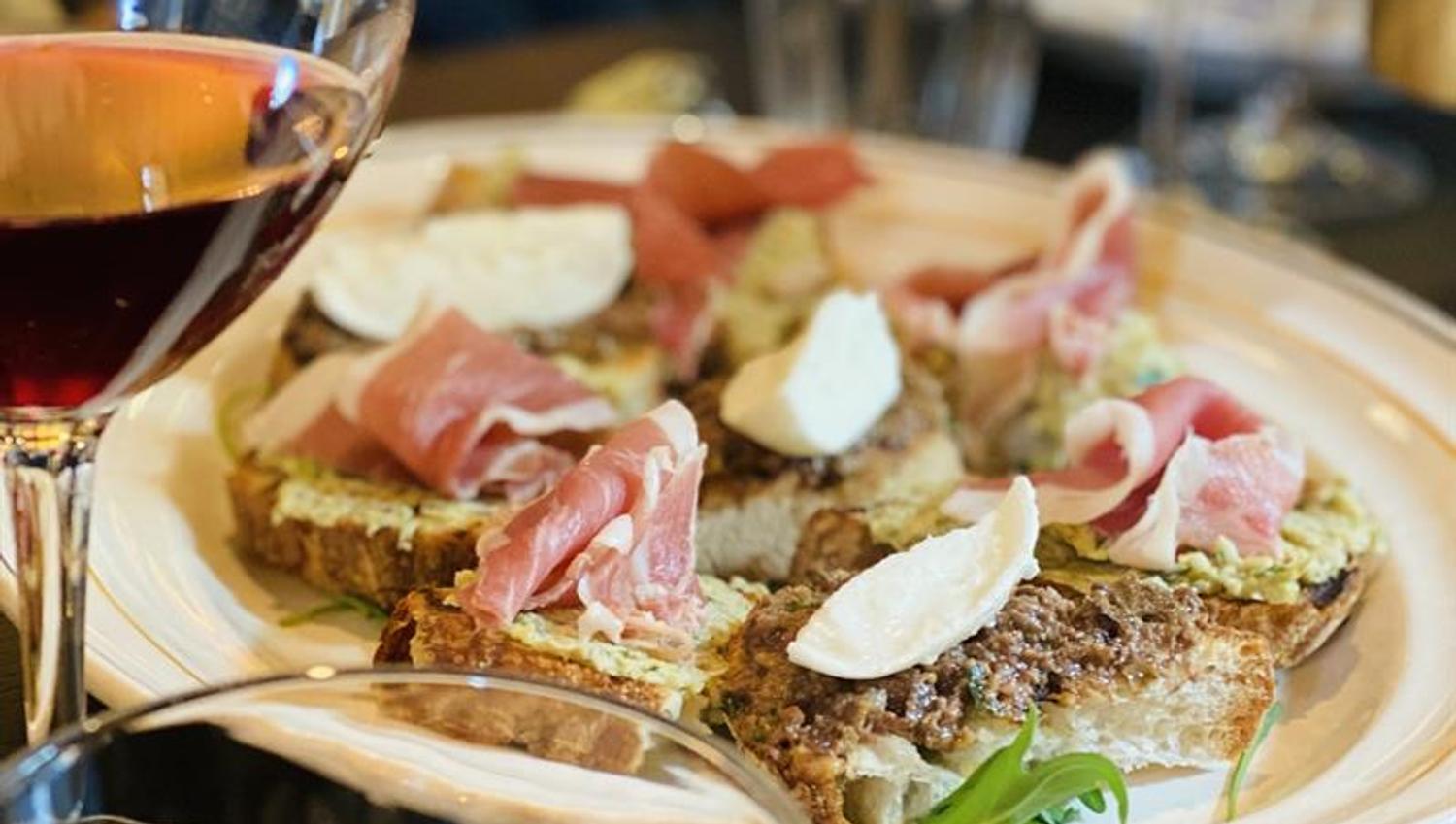 Detaljbilde matrett og glass med vin.