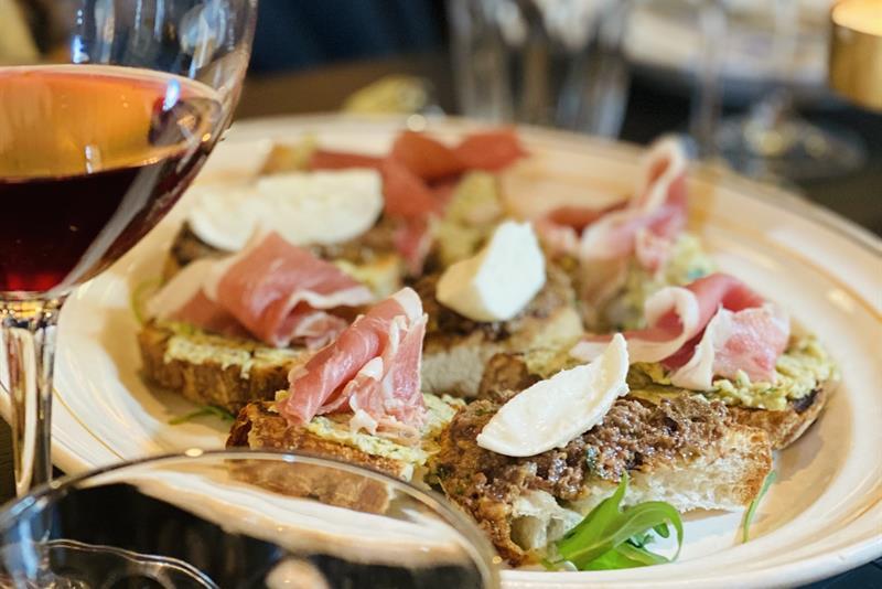 Detaljbilde matrett og glass med vin.