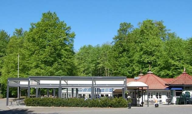 The restaurant in the foreground with a green beech forest behind.