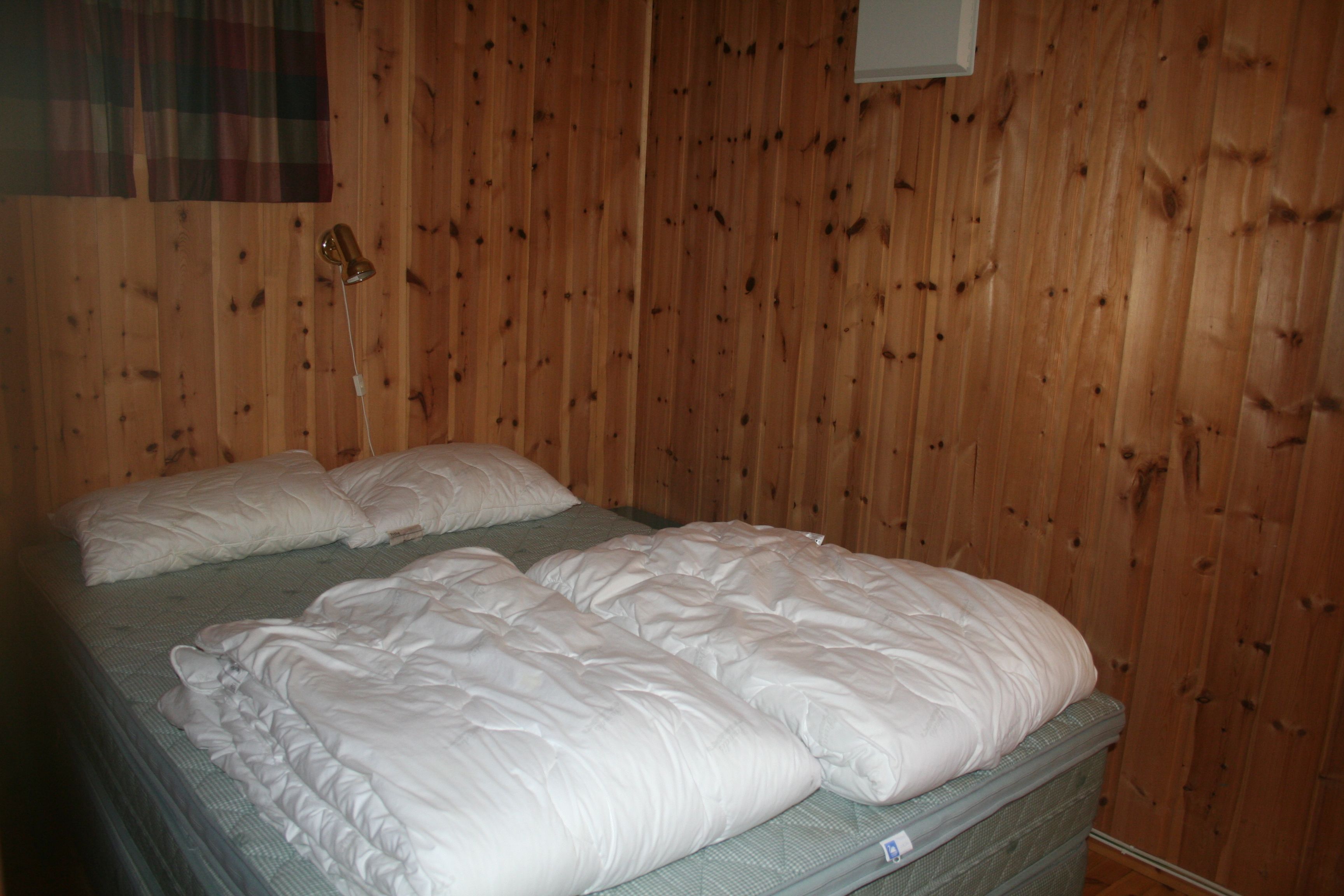 Cozy bedroom with a double bed and traditional Norwegian cabin style.