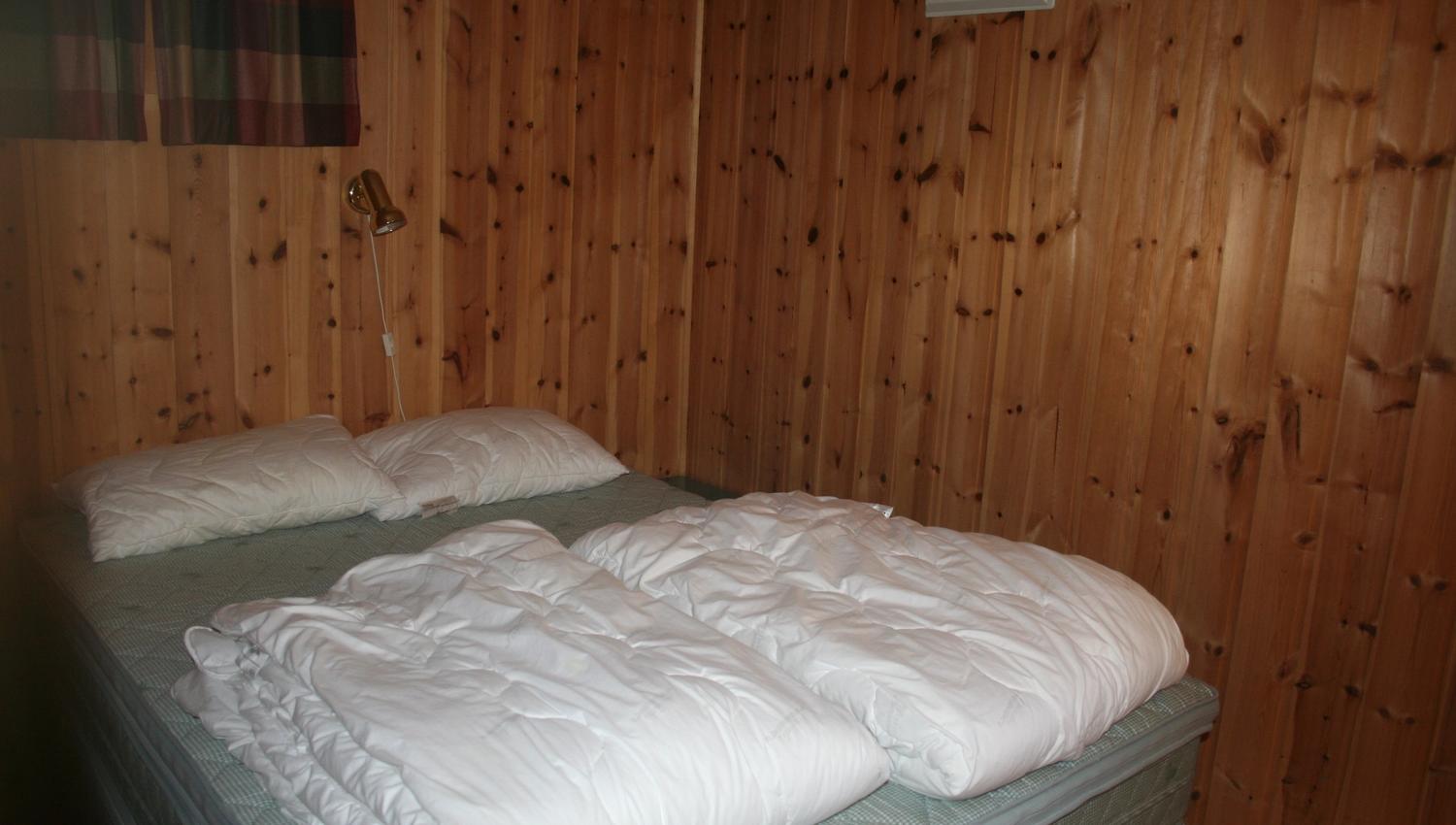 Cozy bedroom with a double bed and traditional Norwegian cabin style.
