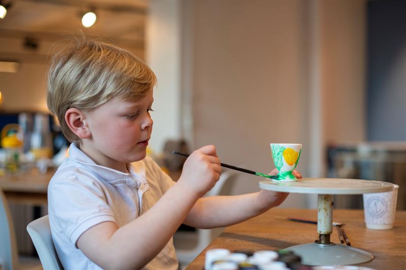 boy painting a cup at the porcelain museum in Porsgrunn