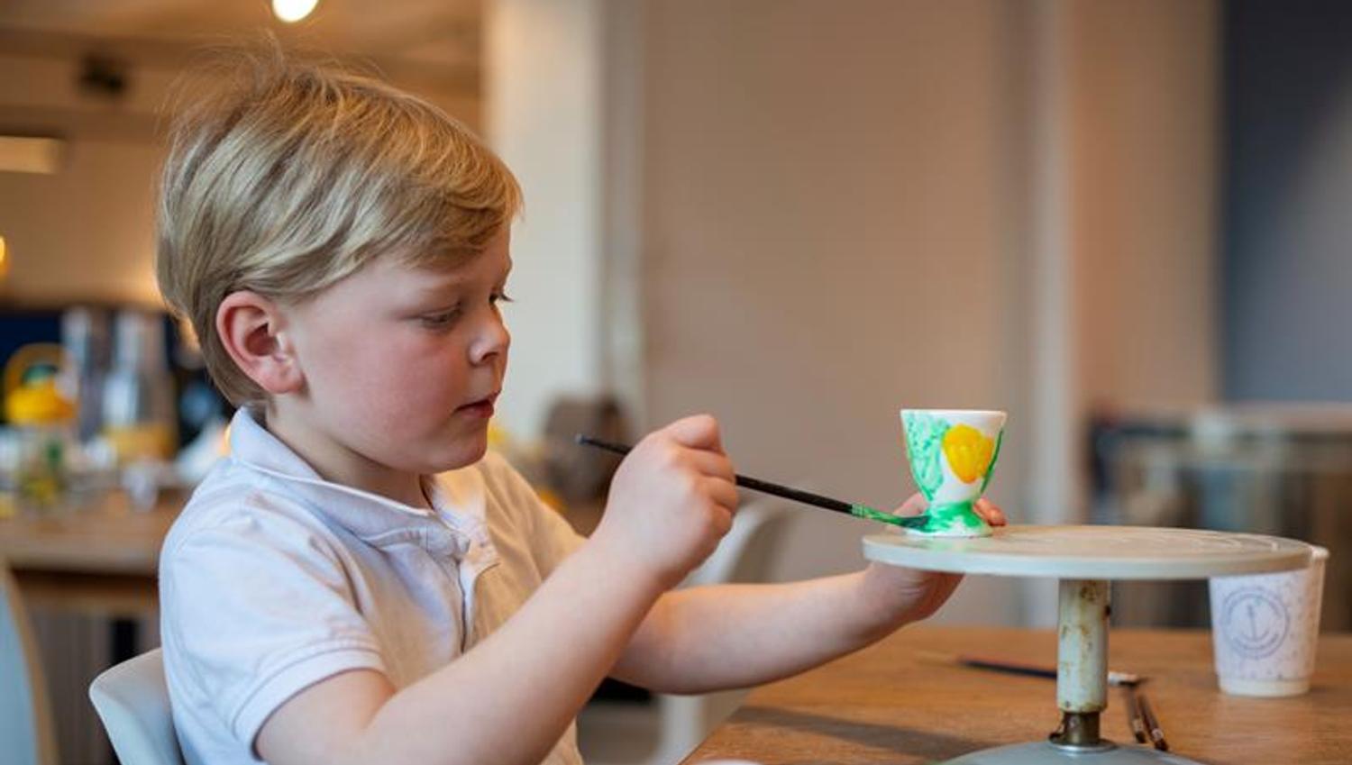 boy painting a cup at the porcelain museum in Porsgrunn