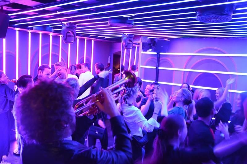 musikere spiller mens en gruppe mennesker danser til musikken