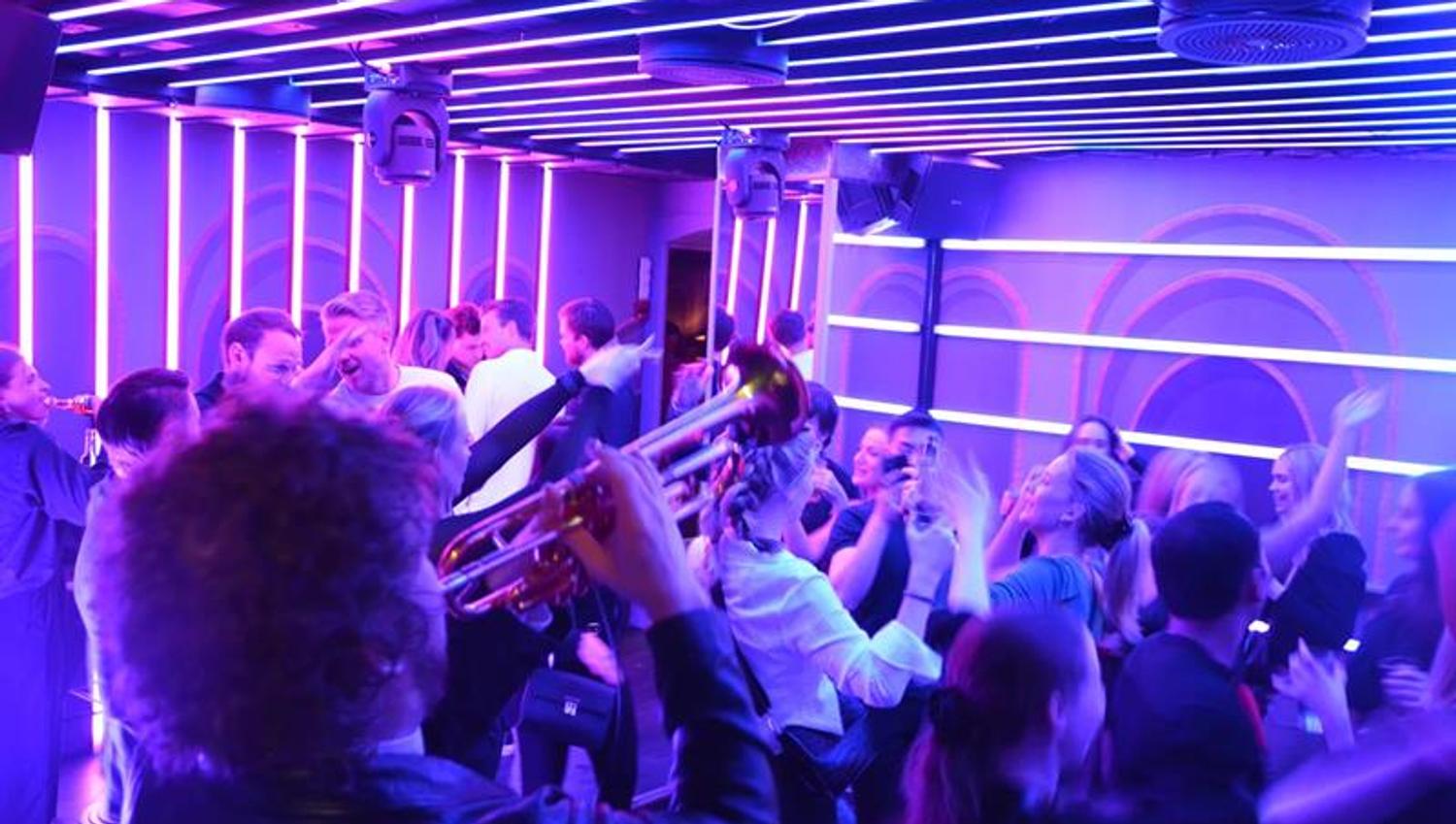 musikere spiller mens en gruppe mennesker danser til musikken