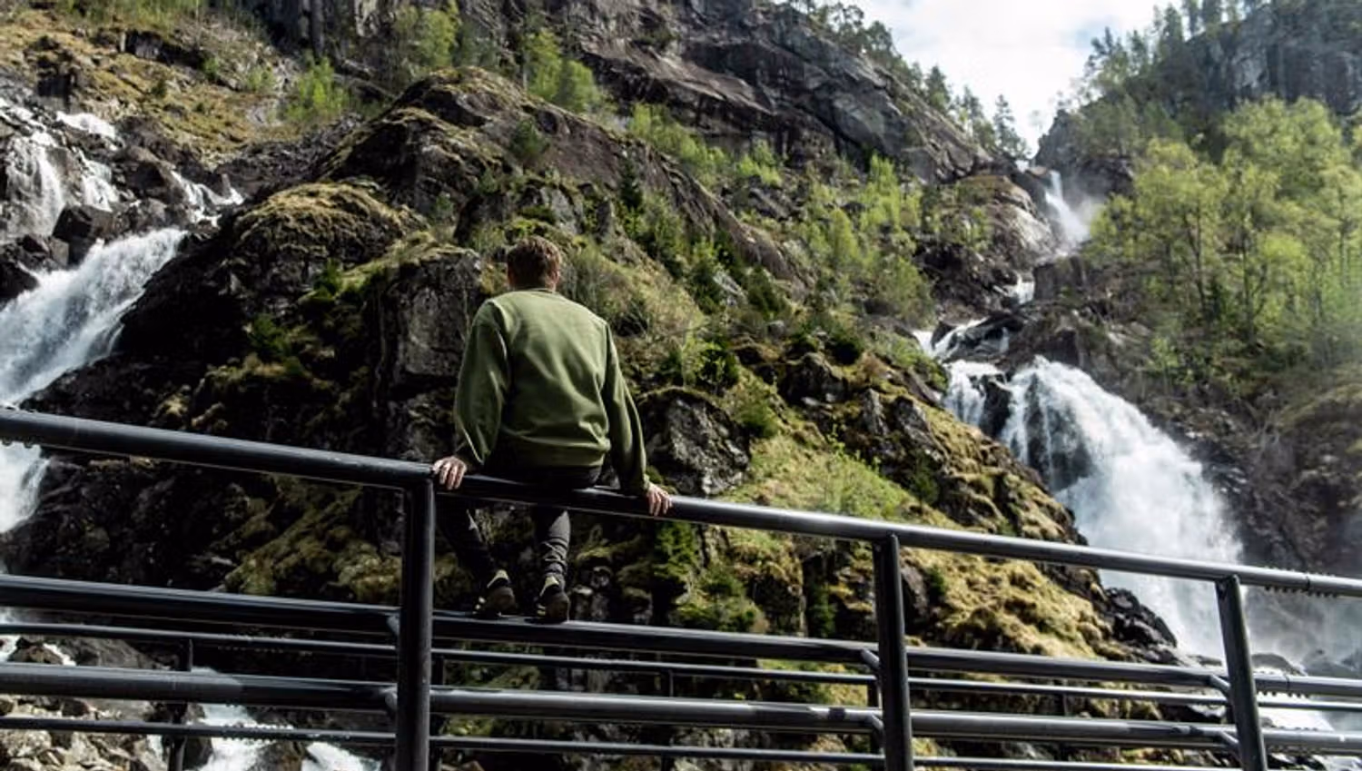 Mann nyt utsikta frå rekkverket ved Låtefoss i Hardanger, Noreg.