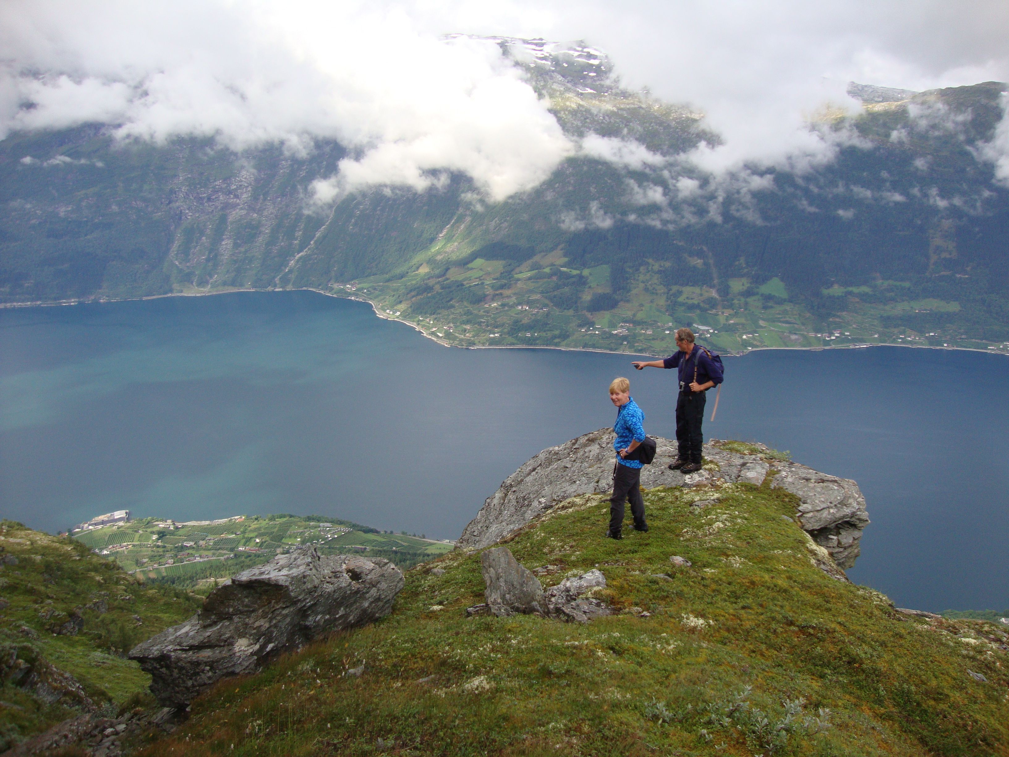 To turgåarar på toppen av eit fjell på Dronningstien, med utsikt over Hardangerfjorden.