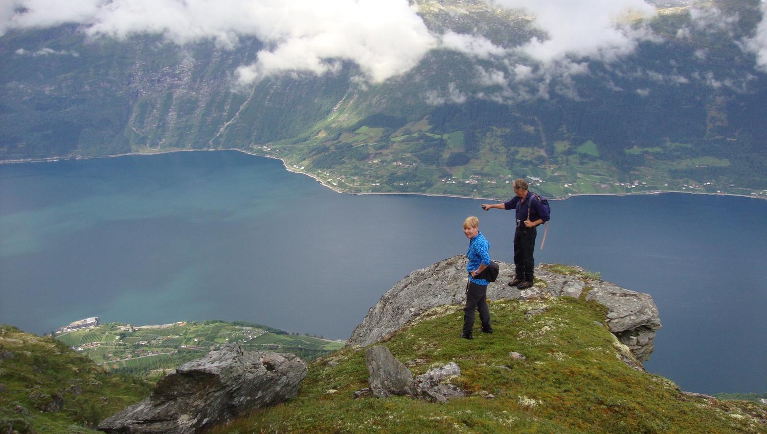 To turgåarar på toppen av eit fjell på Dronningstien, med utsikt over Hardangerfjorden.