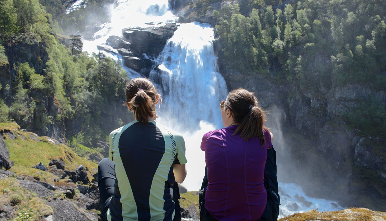 Two friends looking at one of four waterfalls in Husedalen. 