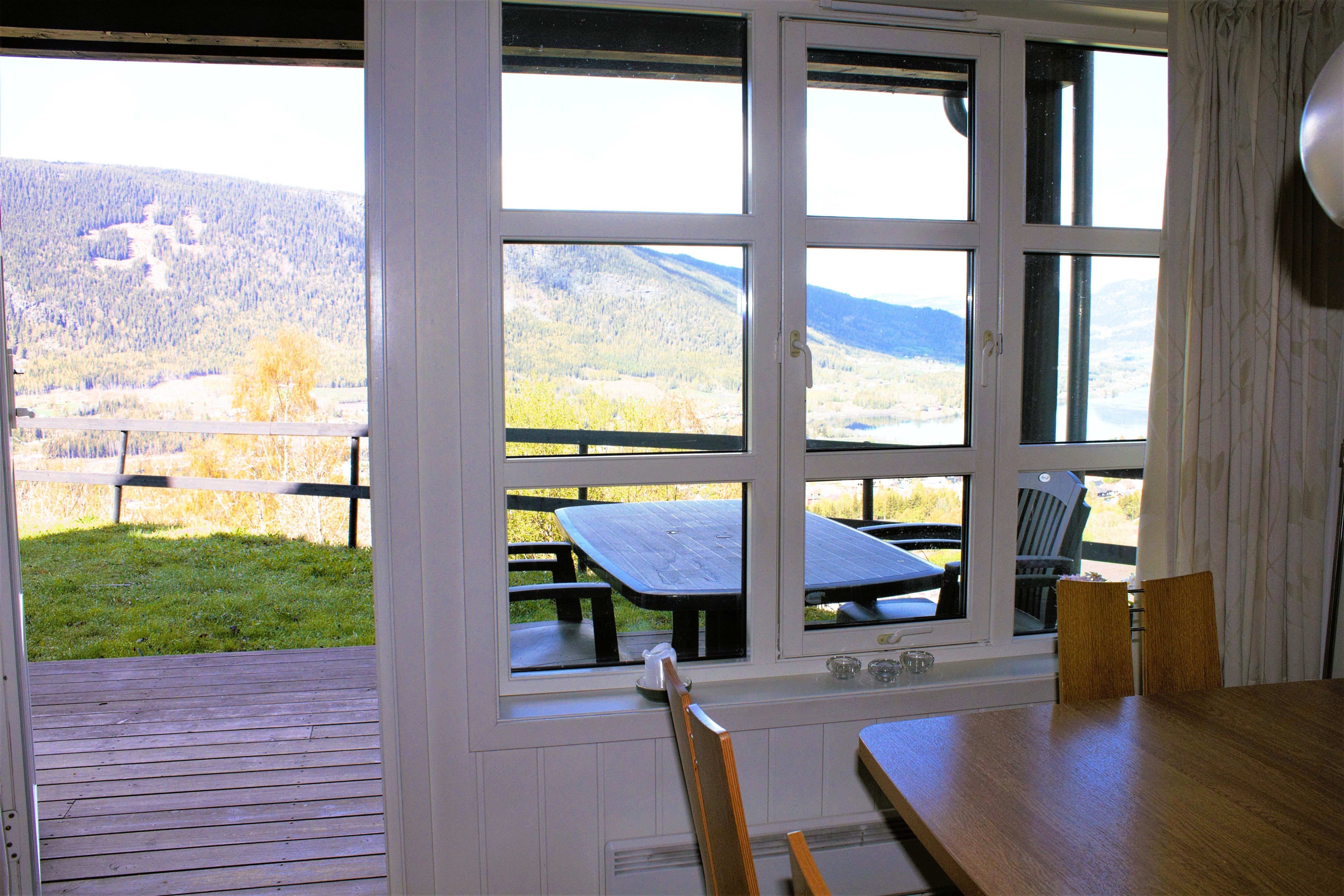 A table and chairs outside a window.