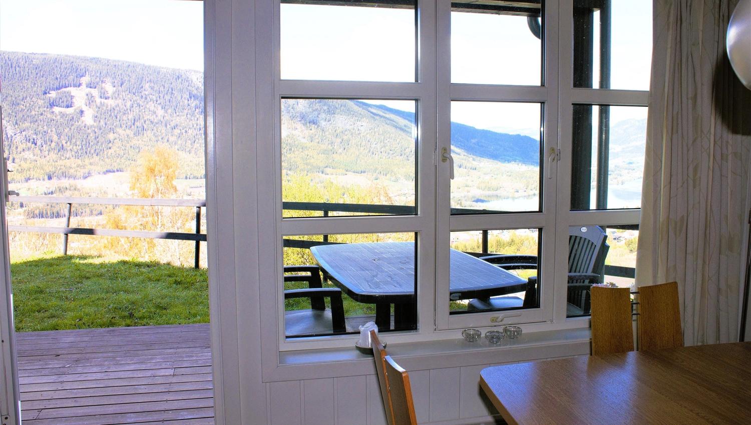 A table and chairs outside a window.