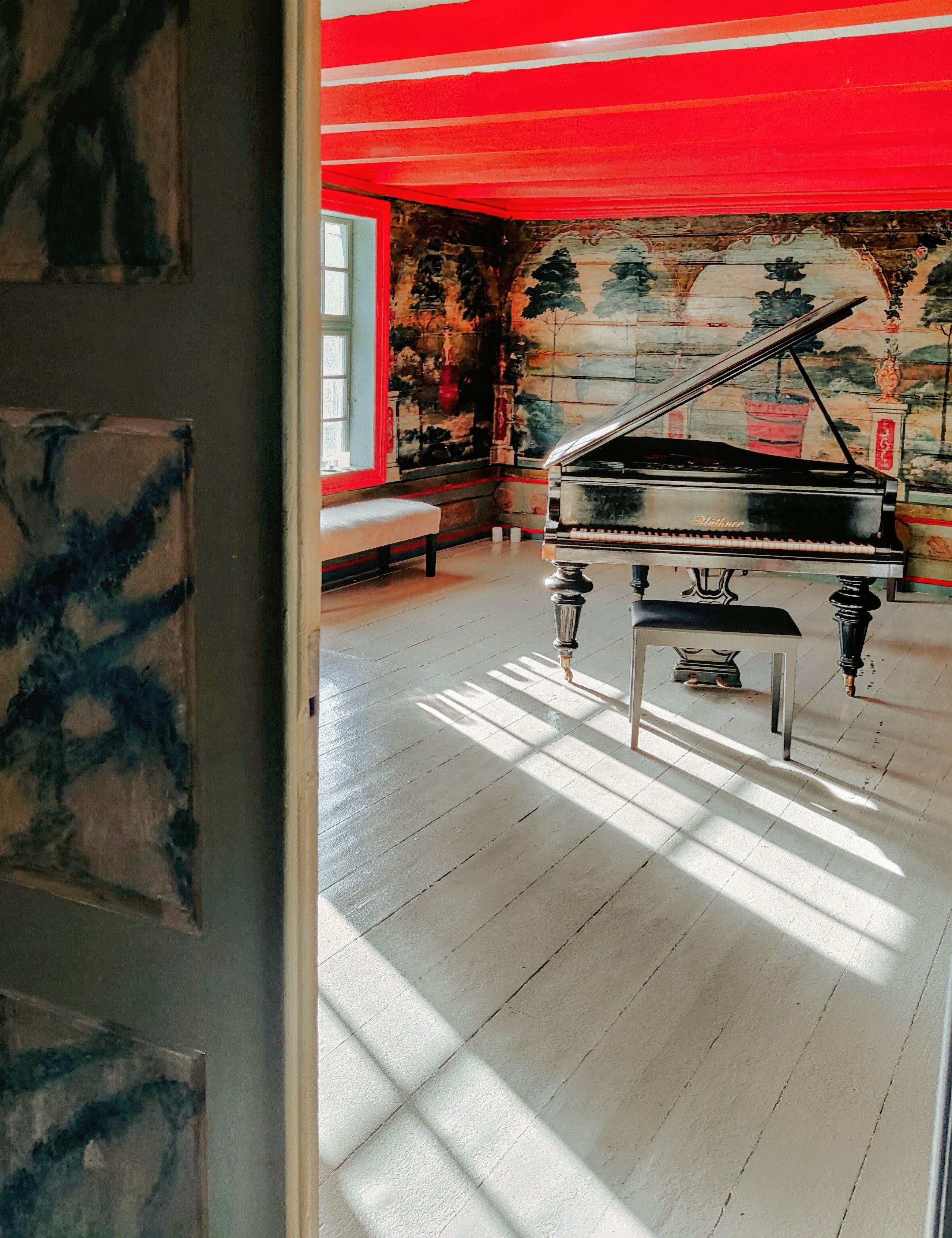 The Red Hall at Skrivergaarden with red walls, decorative paintings and historic interior details.