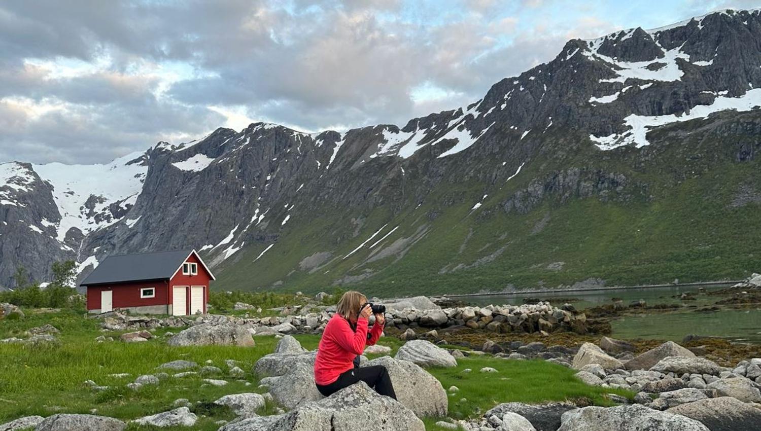 A person taking pictures with the mountains in the back