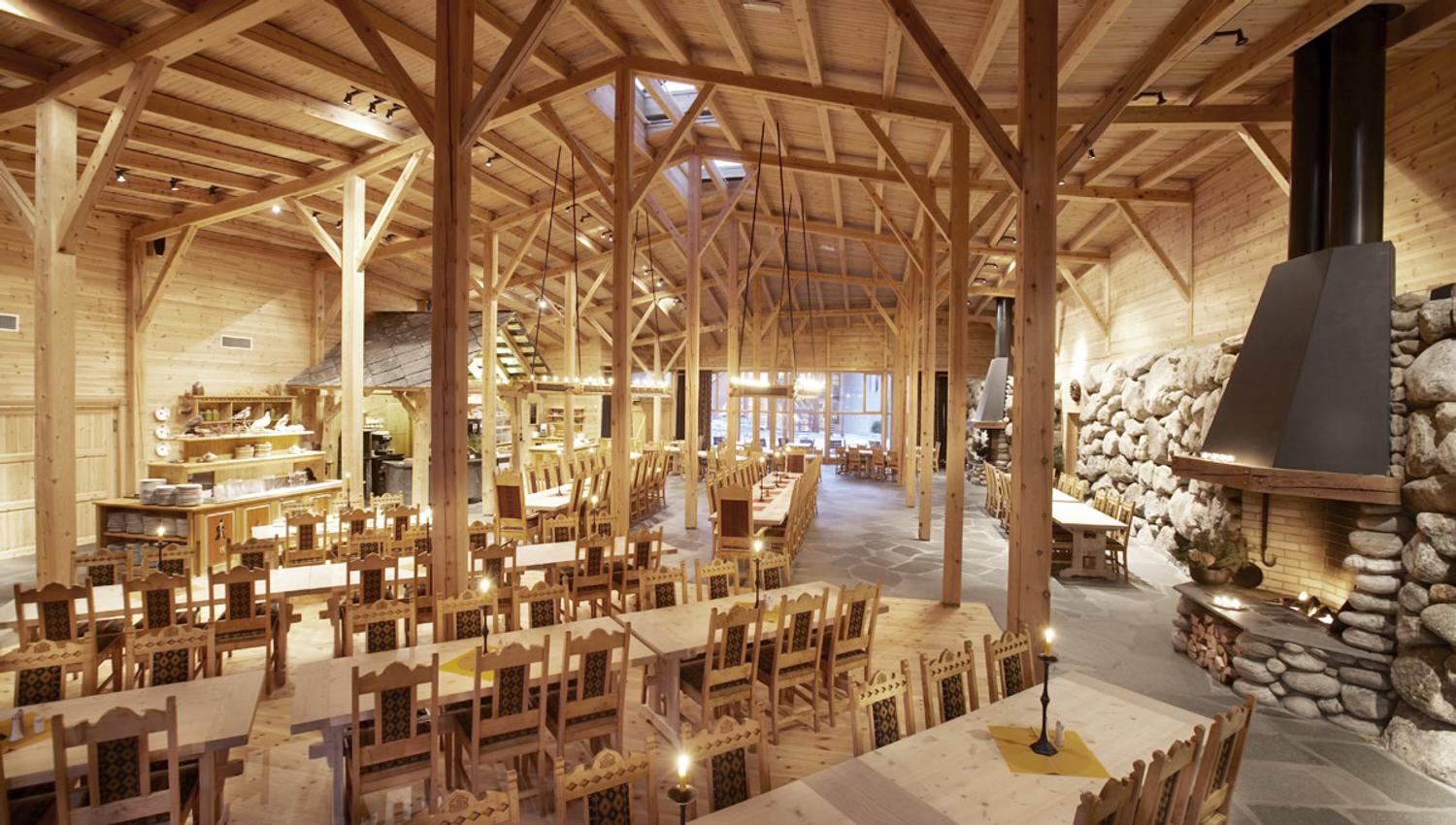The restaurant from the inside, with wooden ceiling, rock walls and wooden, handcarved tables and chairs.