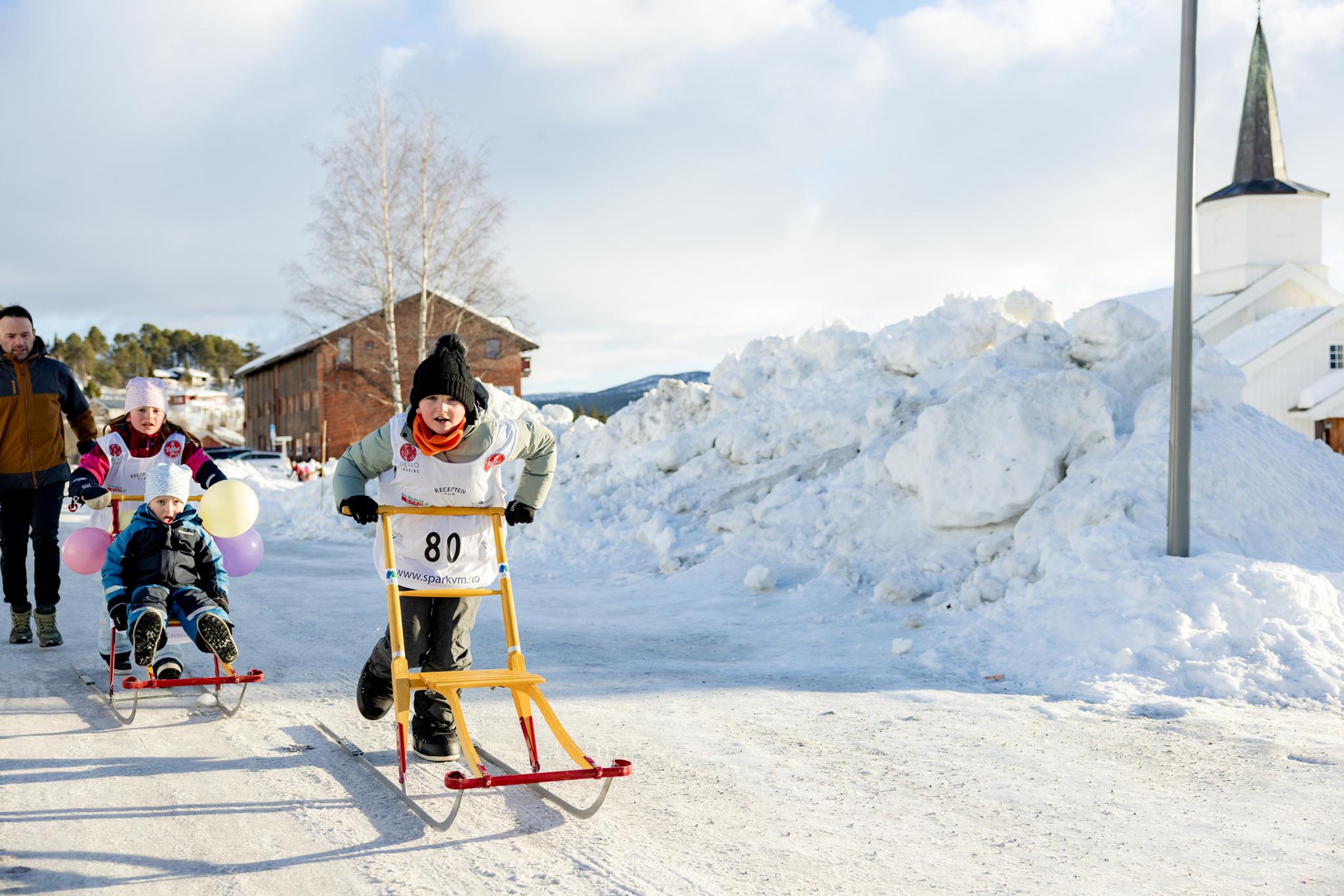 A group of children on kicksleds during the Kicksled World Championship in downtown Geilo.