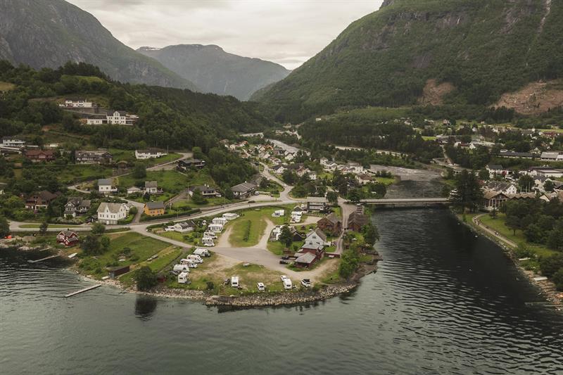 A drone photo of the camping place with the village and mountains in the background.