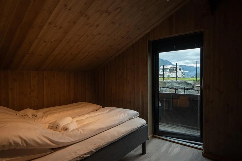 Soverom i leilegheita på Lothepus Camping med utgang til balkong og utsikt mot campingplassen og fjella
