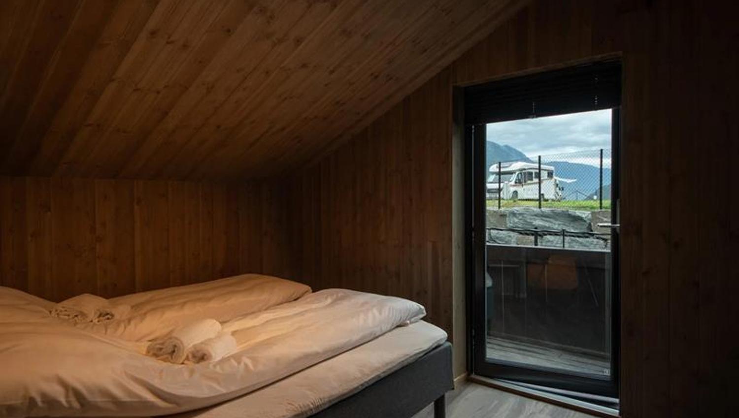 Soverom i leilegheita på Lothepus Camping med utgang til balkong og utsikt mot campingplassen og fjella