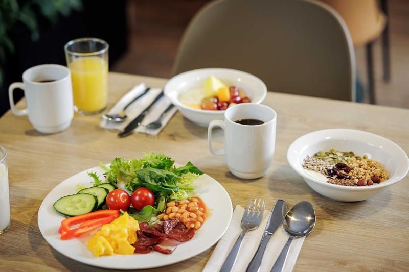 Frokosttallerkener, kaffekopper og et glass med juice