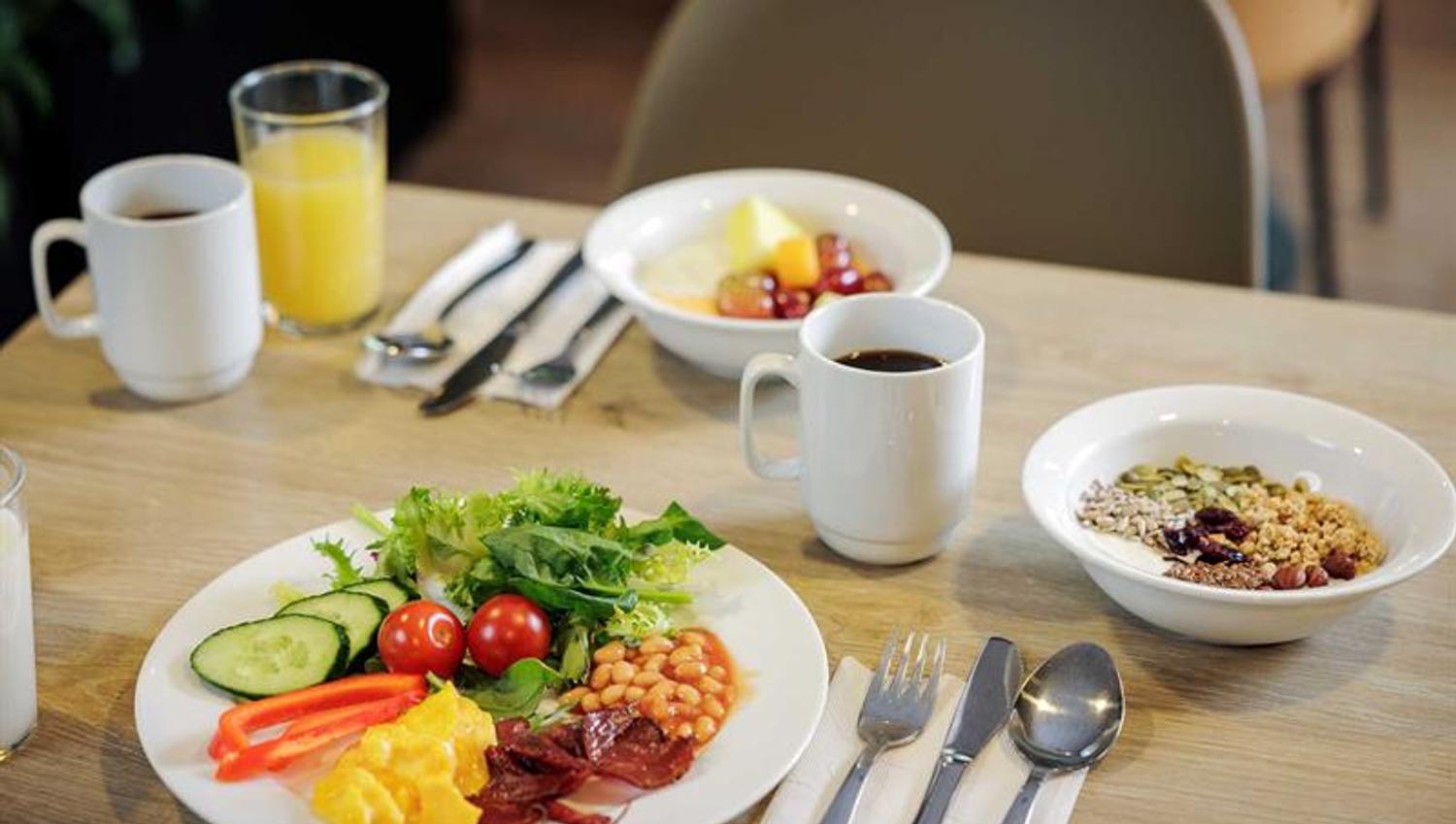 Frokosttallerkener, kaffekopper og et glass med juice