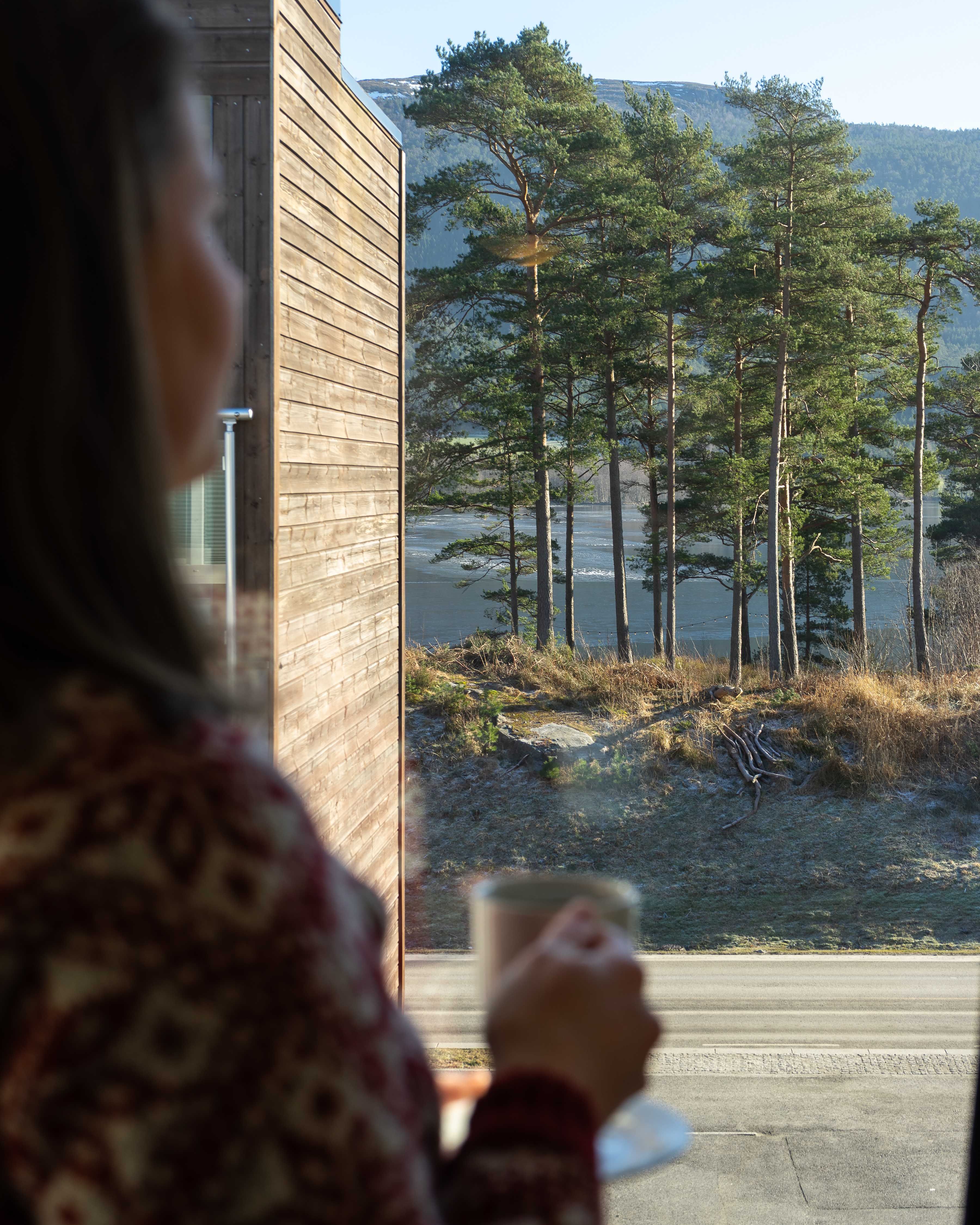 Utsikt mot fjord og skog frå eit rom på Husnes Sentrum Hotell.