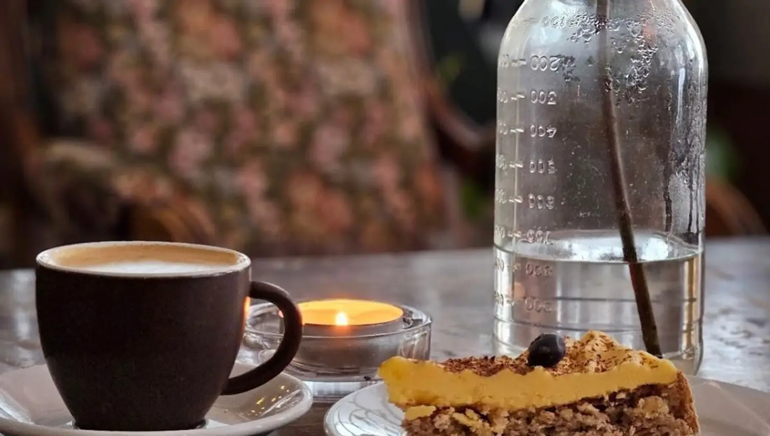 Coffee, cake, and water on the table