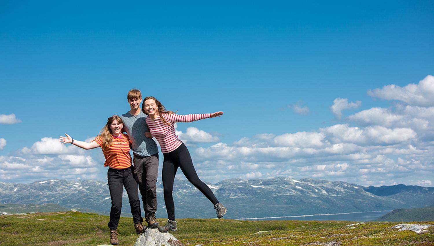boy and 2 girls balancing on a rock
