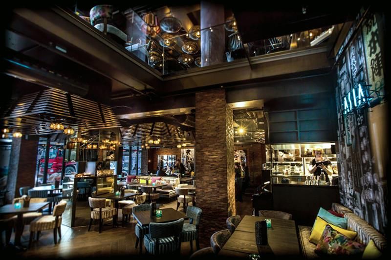 Restaurant interior with seating section, tables and chairs. Two stories.
