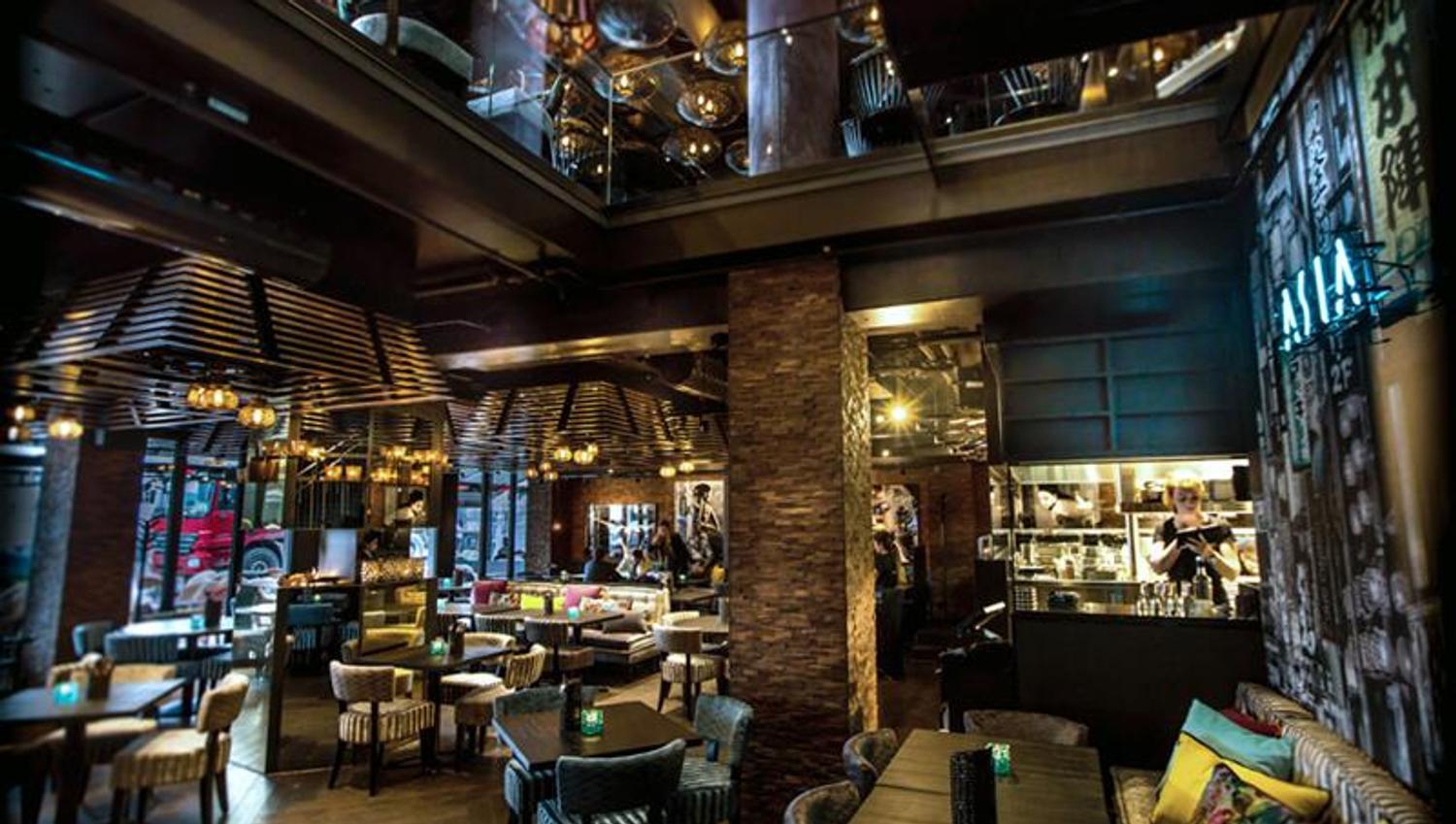 Restaurant interior with seating section, tables and chairs. Two stories.
