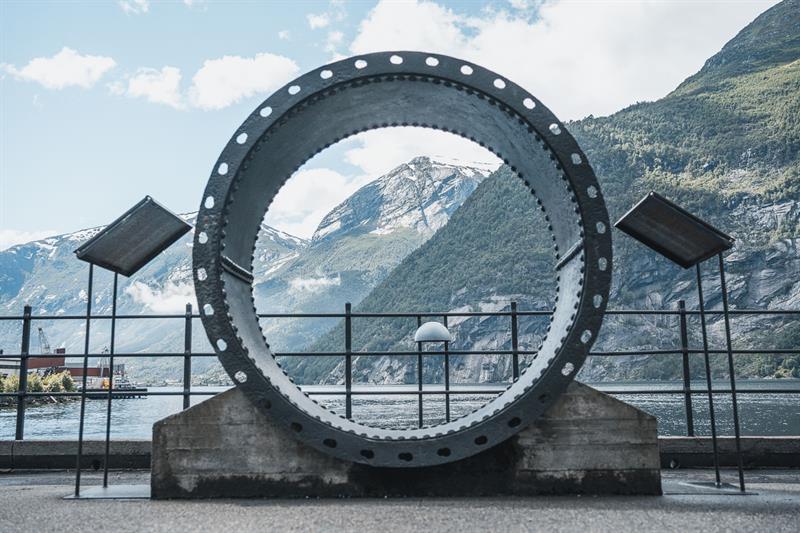 Outdoor exhibit at the Kraftmuseet featuring a large turbine ring with views of the fjord and mountains in Hardanger.