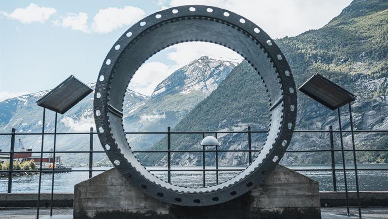 Outdoor exhibit at the Kraftmuseet featuring a large turbine ring with views of the fjord and mountains in Hardanger.