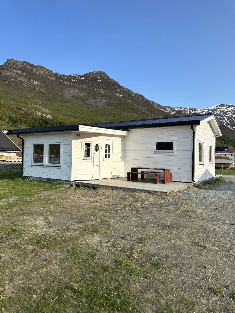 A white cabin with a outside deck 