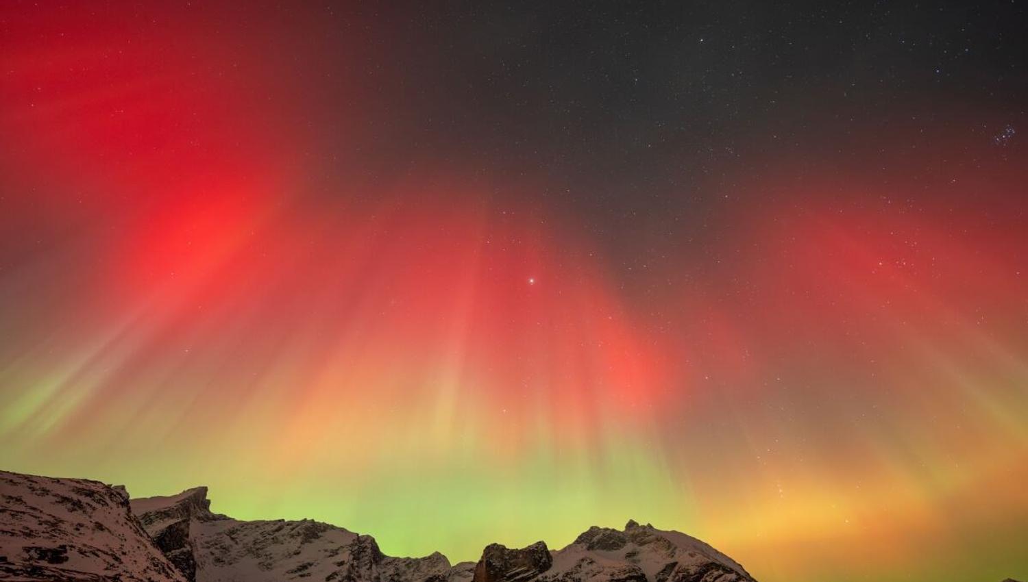 Red, orange and green Northern Lights light up the sky