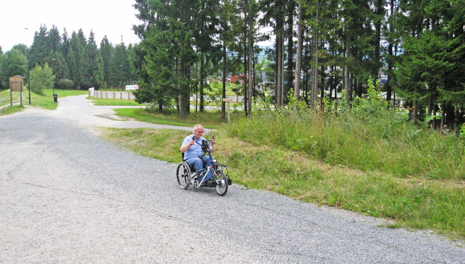 man in a wheelchair drives on the hiking trails in Skien leisure park