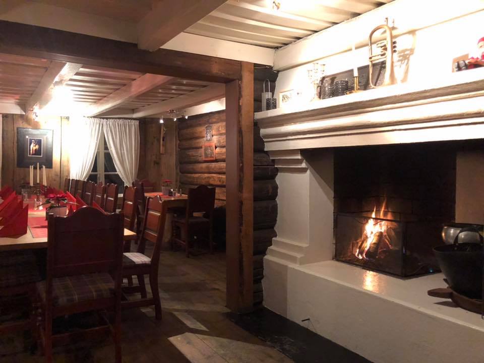 Inside the restaurant. Chairs and table near the fireplace.