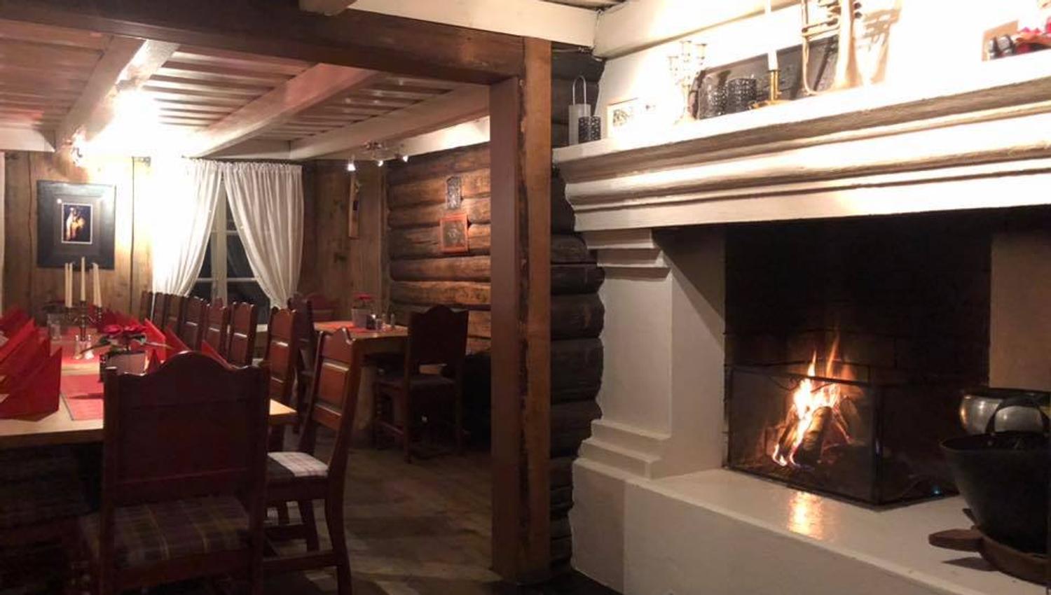 Inside the restaurant. Chairs and table near the fireplace.