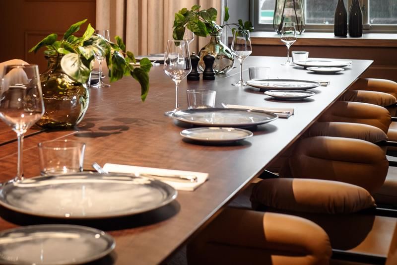 A long table set for dining, with chairs.