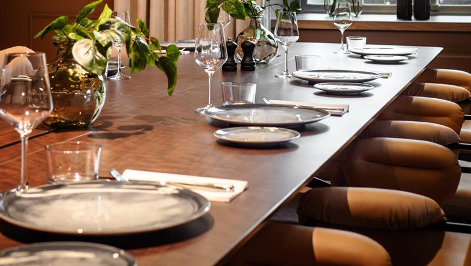 A long table set for dining, with chairs.