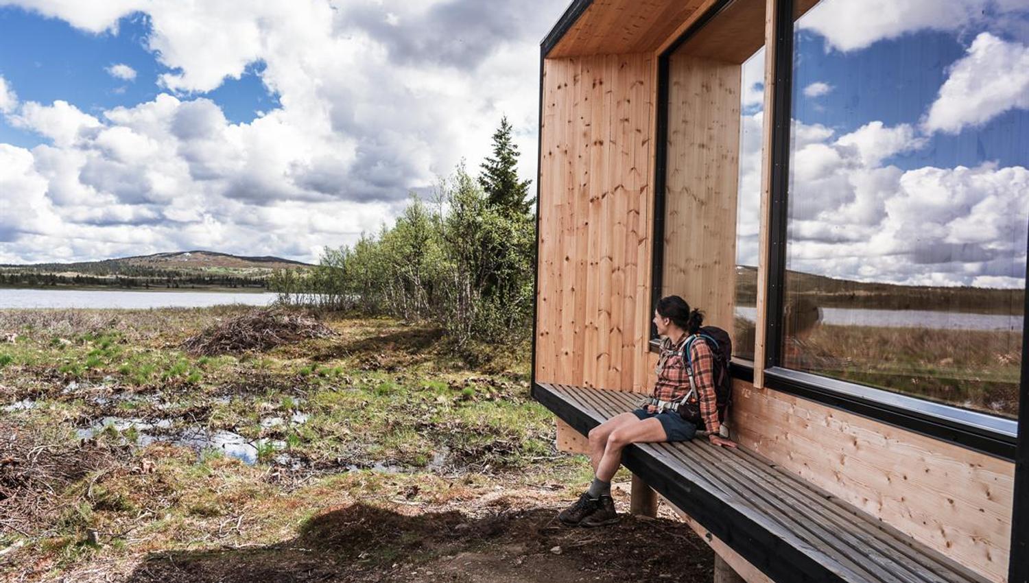 Person sitting at a modern viewpoint in the mountains