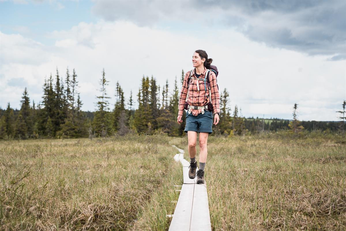 Person walking on a path through open landscape